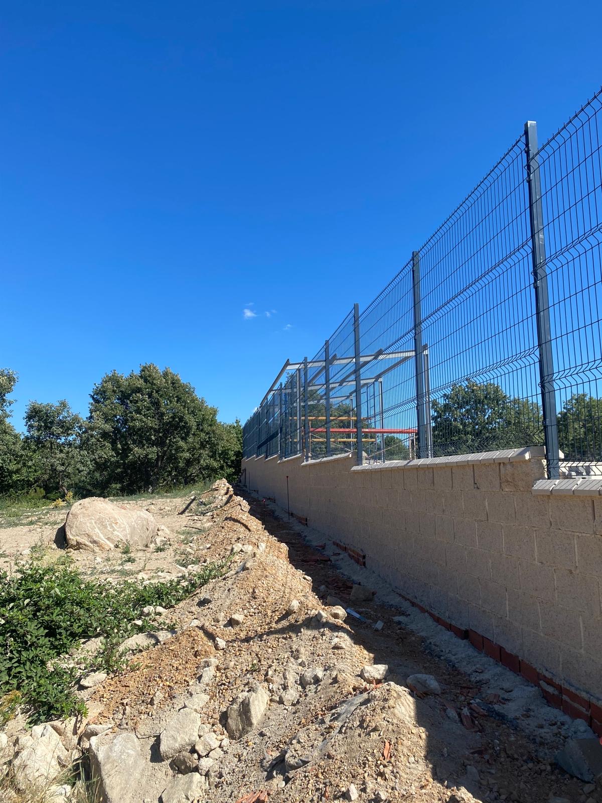 Panel plegado con postes metálicos sobre muro escalonado