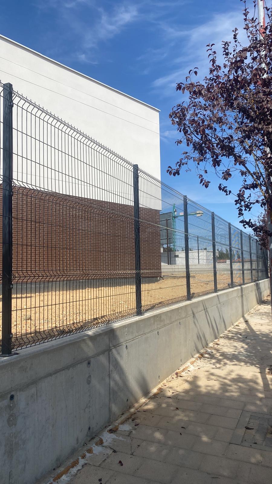 Vallado de panel plegado gris junto a un edificio